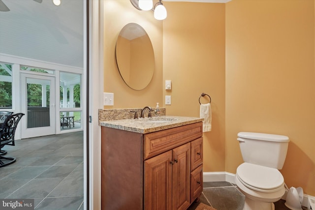 bathroom with vanity, toilet, and baseboards