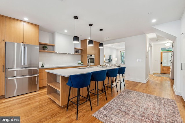 kitchen featuring open shelves, appliances with stainless steel finishes, a breakfast bar, light wood-style floors, and recessed lighting
