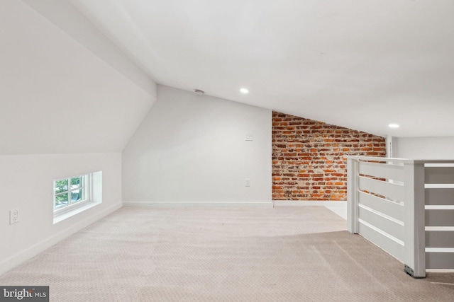 additional living space with lofted ceiling, carpet floors, baseboards, brick wall, and recessed lighting