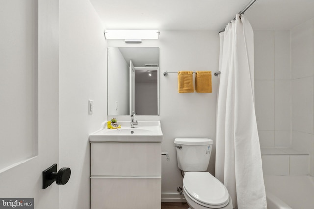 full bath with toilet, vanity, and shower / bath combo