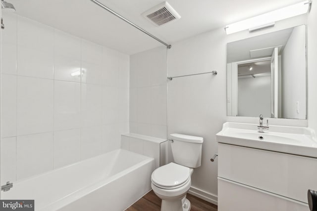 full bath featuring wood finished floors, toilet, vanity, shower / bath combination, and baseboards