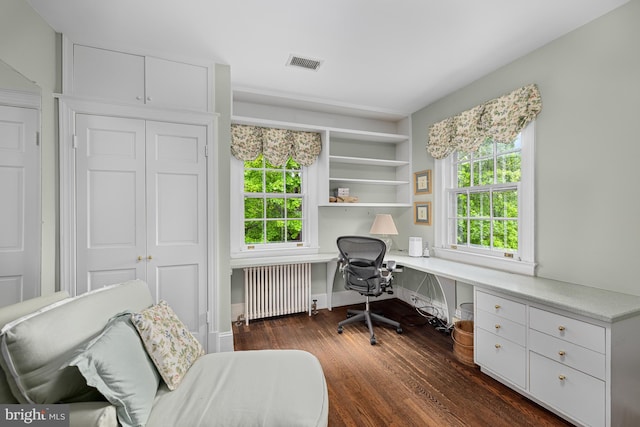 home office with radiator heating unit, built in desk, and dark wood-type flooring