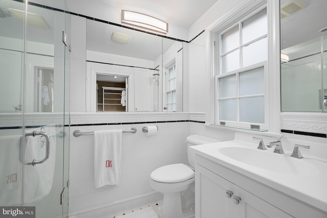 full bath with tile walls, a shower stall, toilet, and vanity