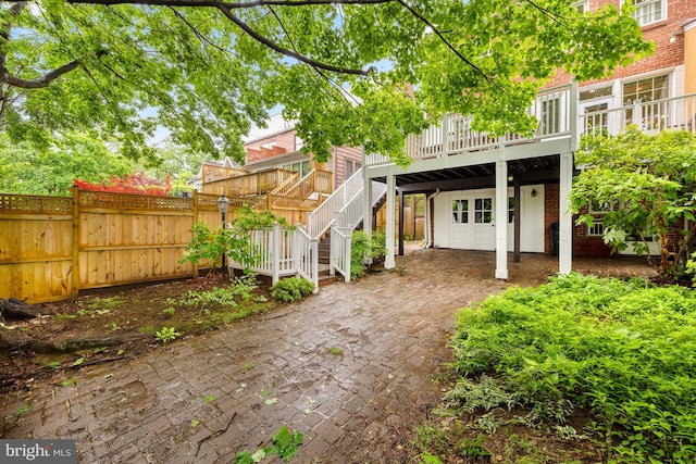 back of house with fence and a wooden deck