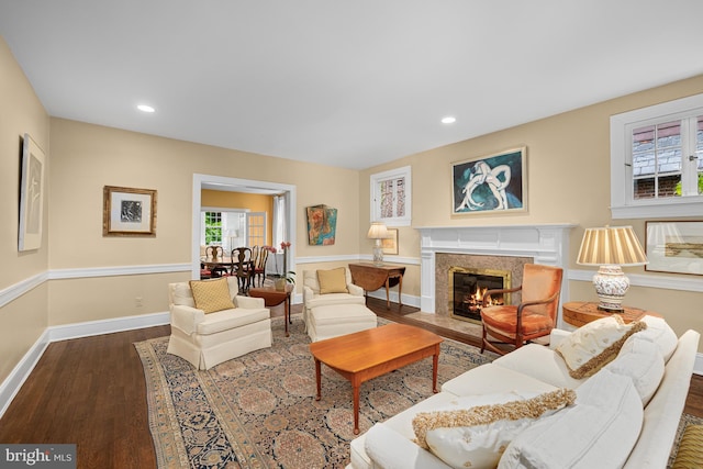 living room with wood finished floors, a high end fireplace, baseboards, and recessed lighting