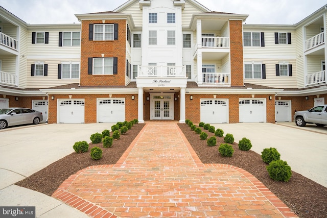 multi unit property with brick siding, french doors, and driveway