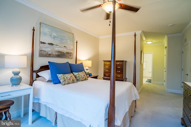 bedroom featuring ornamental molding, light colored carpet, baseboards, a ceiling fan, and ensuite bathroom