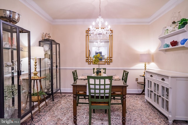 dining room with a chandelier, wood finished floors, ornamental molding, and baseboards