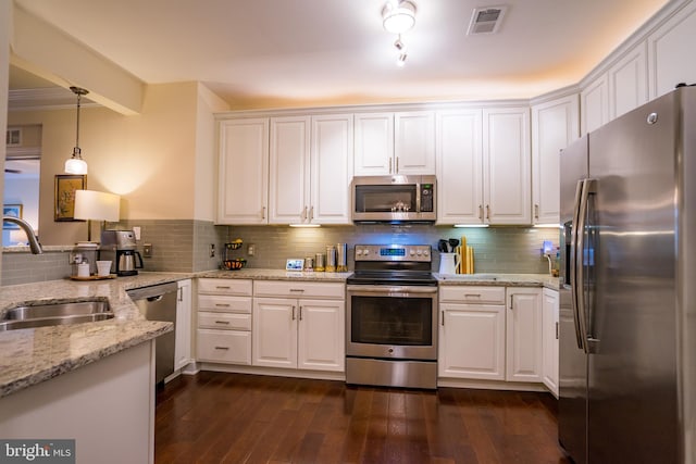 kitchen featuring stainless steel appliances, a sink, white cabinetry, tasteful backsplash, and light stone countertops