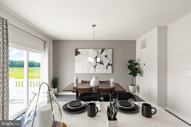 dining space featuring a chandelier and baseboards