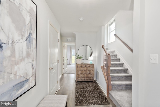 staircase with baseboards and wood finished floors