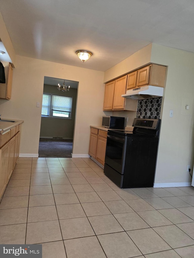 13103 Chalfont Ave, Fort Washington, MD 20744 - kitchen featuring black electric range, under cabinet range hood, light tile patterned floors, a chandelier, and baseboards