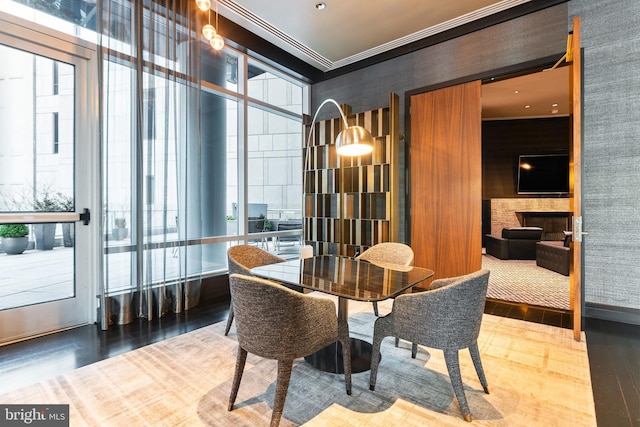 1414 S Penn Sq Unit 18H, Philadelphia, PA 19102 - dining space featuring wood finished floors, healthy amount of natural light, a fireplace, and ornamental molding