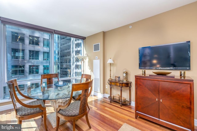 1414 S Penn Sq Unit 18H, Philadelphia, PA 19102 - dining space with wood finished floors, baseboards, and expansive windows