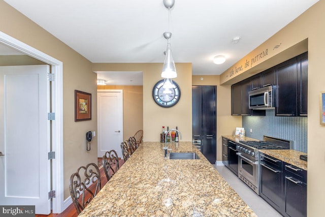 1414 S Penn Sq Unit 18H, Philadelphia, PA 19102 - kitchen featuring a sink, stainless steel appliances, tasteful backsplash, light stone countertops, and hanging light fixtures