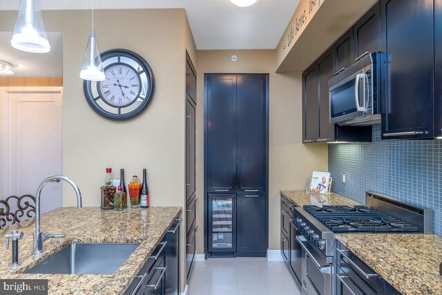 1414 S Penn Sq Unit 18H, Philadelphia, PA 19102 - kitchen with appliances with stainless steel finishes, a sink, light stone counters, tasteful backsplash, and light tile patterned floors