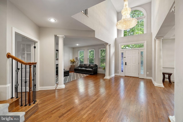 18309 Eldorado Way, Leesburg, VA 20176 - foyer entrance featuring ornate columns, healthy amount of natural light, wood finished floors, and a chandelier