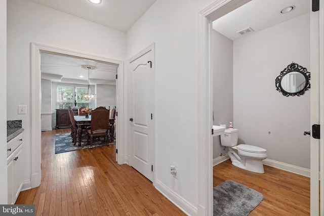 18309 Eldorado Way, Leesburg, VA 20176 - bathroom featuring toilet, wood finished floors, a chandelier, baseboards, and vanity