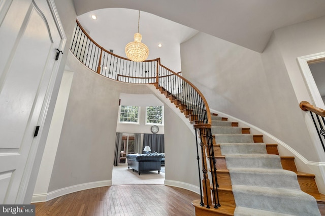 18309 Eldorado Way, Leesburg, VA 20176 - stairs featuring a towering ceiling, hardwood / wood-style floors, a chandelier, baseboards, and recessed lighting