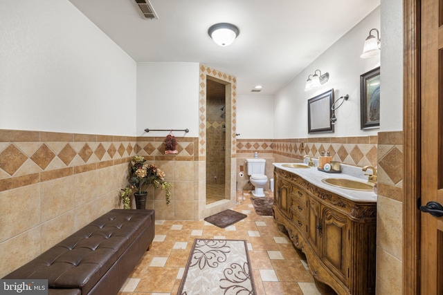 18309 Eldorado Way, Leesburg, VA 20176 - bathroom with tile walls, toilet, wainscoting, double vanity, and a shower stall