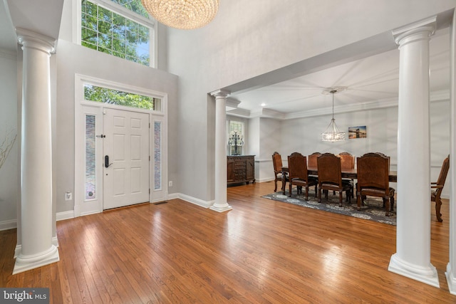 18309 Eldorado Way, Leesburg, VA 20176 - foyer entrance featuring decorative columns, a chandelier, wood-type flooring, baseboards, and crown molding