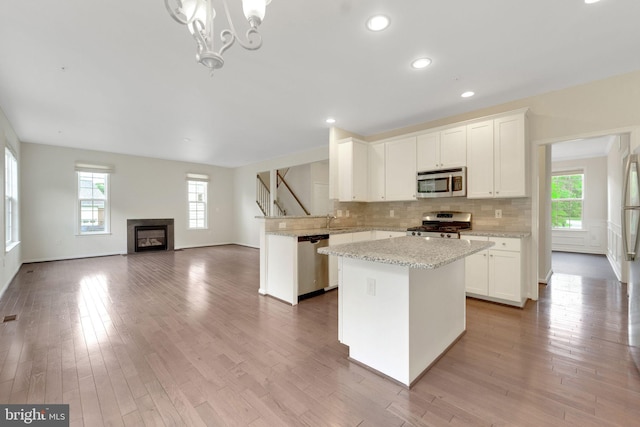 kitchen featuring appliances with stainless steel finishes, plenty of natural light, decorative backsplash, a center island, and recessed lighting