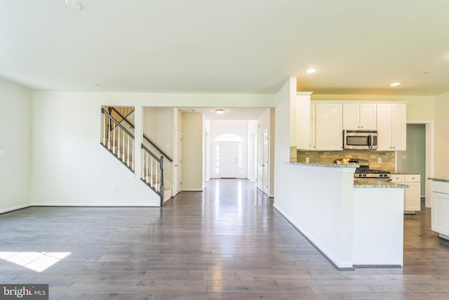 kitchen with stainless steel appliances, dark wood-type flooring, white cabinets, tasteful backsplash, and recessed lighting