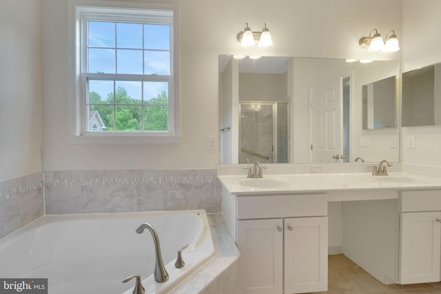 bathroom featuring a bath, a shower stall, double vanity, and tile patterned flooring