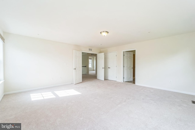 unfurnished bedroom with light carpet and baseboards