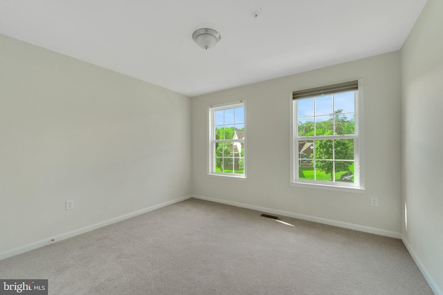 spare room featuring baseboards and carpet