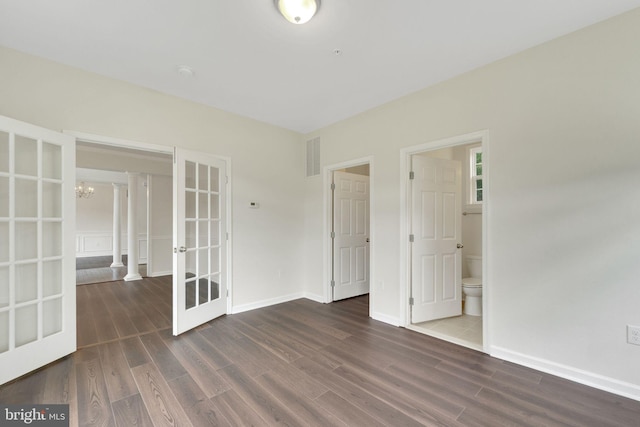 unfurnished bedroom with french doors, wood finished floors, a chandelier, and baseboards