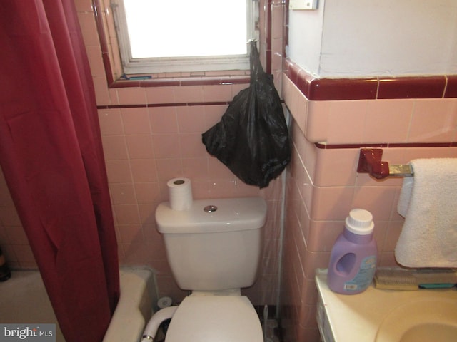full bathroom featuring tile walls and toilet