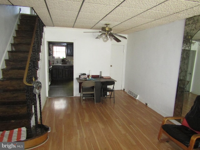 dining space featuring a ceiling fan, stairs, and wood finished floors
