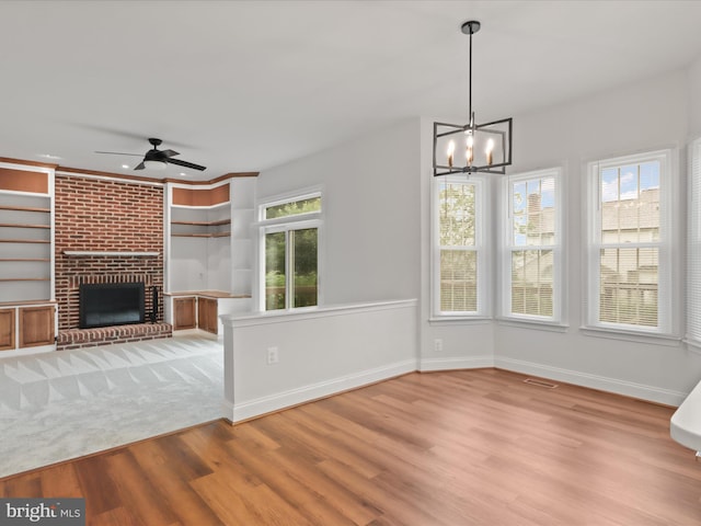 9365 River Crest Rd, Manassas, VA 20110 - unfurnished living room with light wood-style floors, a ceiling fan, a chandelier, a fireplace, and baseboards