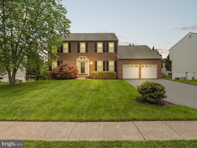 9365 River Crest Rd, Manassas, VA 20110 - colonial-style house with brick siding, a garage, driveway, and a lawn