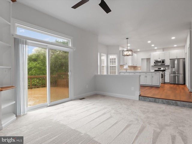 9365 River Crest Rd, Manassas, VA 20110 - unfurnished living room with carpet floors, a ceiling fan, a chandelier, plenty of natural light, and recessed lighting