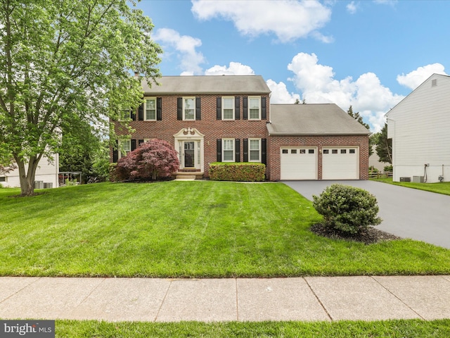 9365 River Crest Rd, Manassas, VA 20110 - colonial home featuring brick siding, an attached garage, concrete driveway, and a front yard