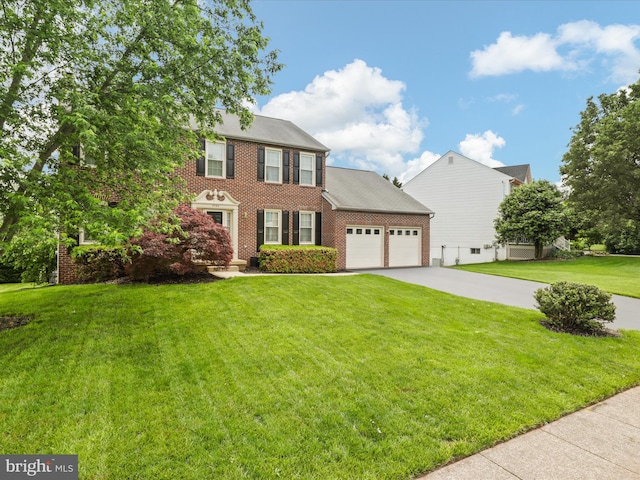 9365 River Crest Rd, Manassas, VA 20110 - colonial inspired home featuring a garage, brick siding, a front lawn, and concrete driveway