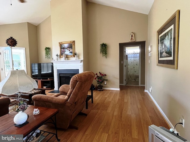 10127 Godspeed Dr, Ocean City, MD 21842 - living room featuring wood finished floors, baseboards, a fireplace, and high vaulted ceiling