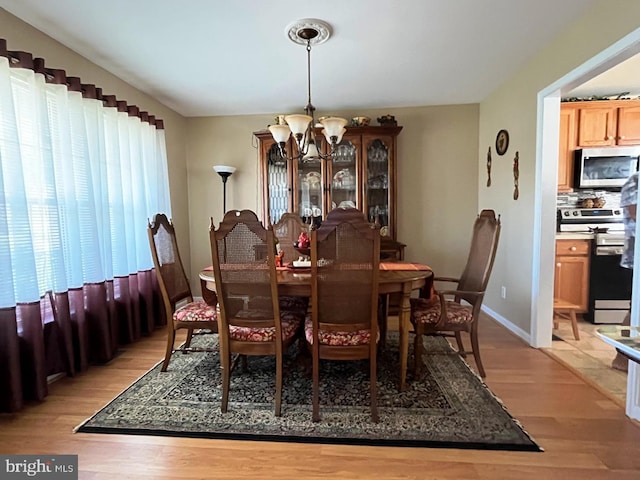 10127 Godspeed Dr, Ocean City, MD 21842 - dining room with a chandelier, light wood-type flooring, and baseboards