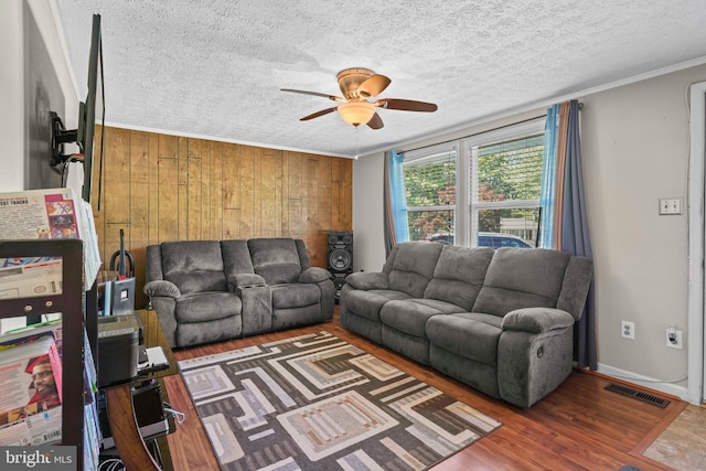 9505 Oakridge Ct, Newburg, MD 20664 - living area with a ceiling fan, wood finished floors, wooden walls, a textured ceiling, and ornamental molding