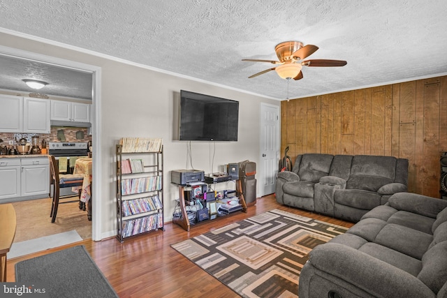 9505 Oakridge Ct, Newburg, MD 20664 - living room with a ceiling fan, wood walls, wood finished floors, a textured ceiling, and ornamental molding