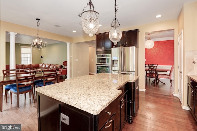 23166 Glenorchy Ct, Ashburn, VA 20148 - kitchen with appliances with stainless steel finishes, ornate columns, decorative light fixtures, light stone counters, and wood finished floors