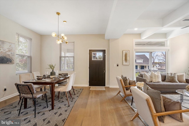 dining space with light wood-style flooring, plenty of natural light, and a chandelier
