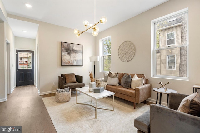 living area featuring a chandelier, baseboards, light wood-style floors, and recessed lighting