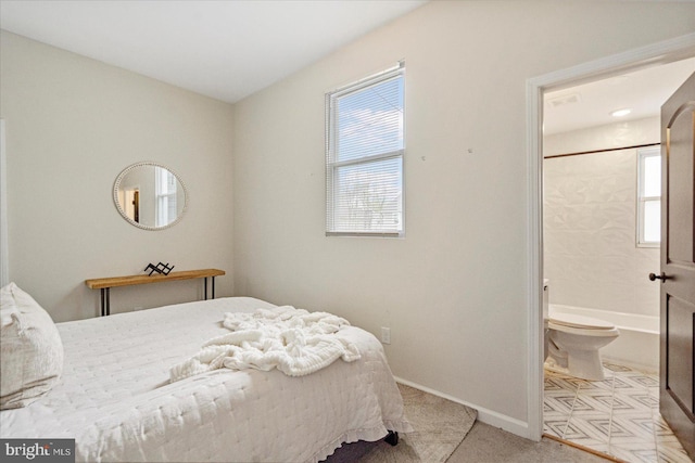 carpeted bedroom with baseboards and ensuite bath