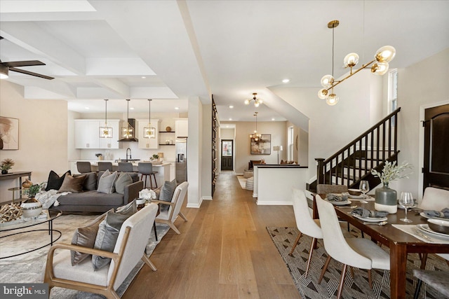 living area featuring recessed lighting, stairway, wood finished floors, a chandelier, and ceiling fan