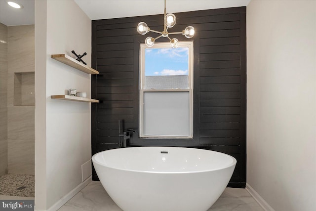 full bath with marble finish floors, baseboards, a chandelier, and a soaking tub