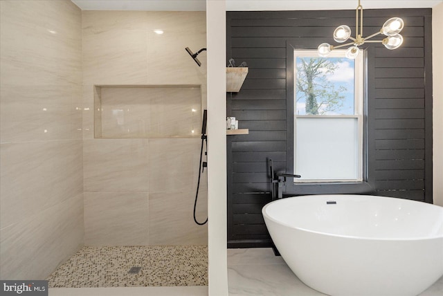 bathroom with tiled shower, marble look tiles, a soaking tub, and a chandelier