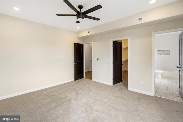 unfurnished bedroom with carpet flooring, a spacious closet, recessed lighting, baseboards, and a closet